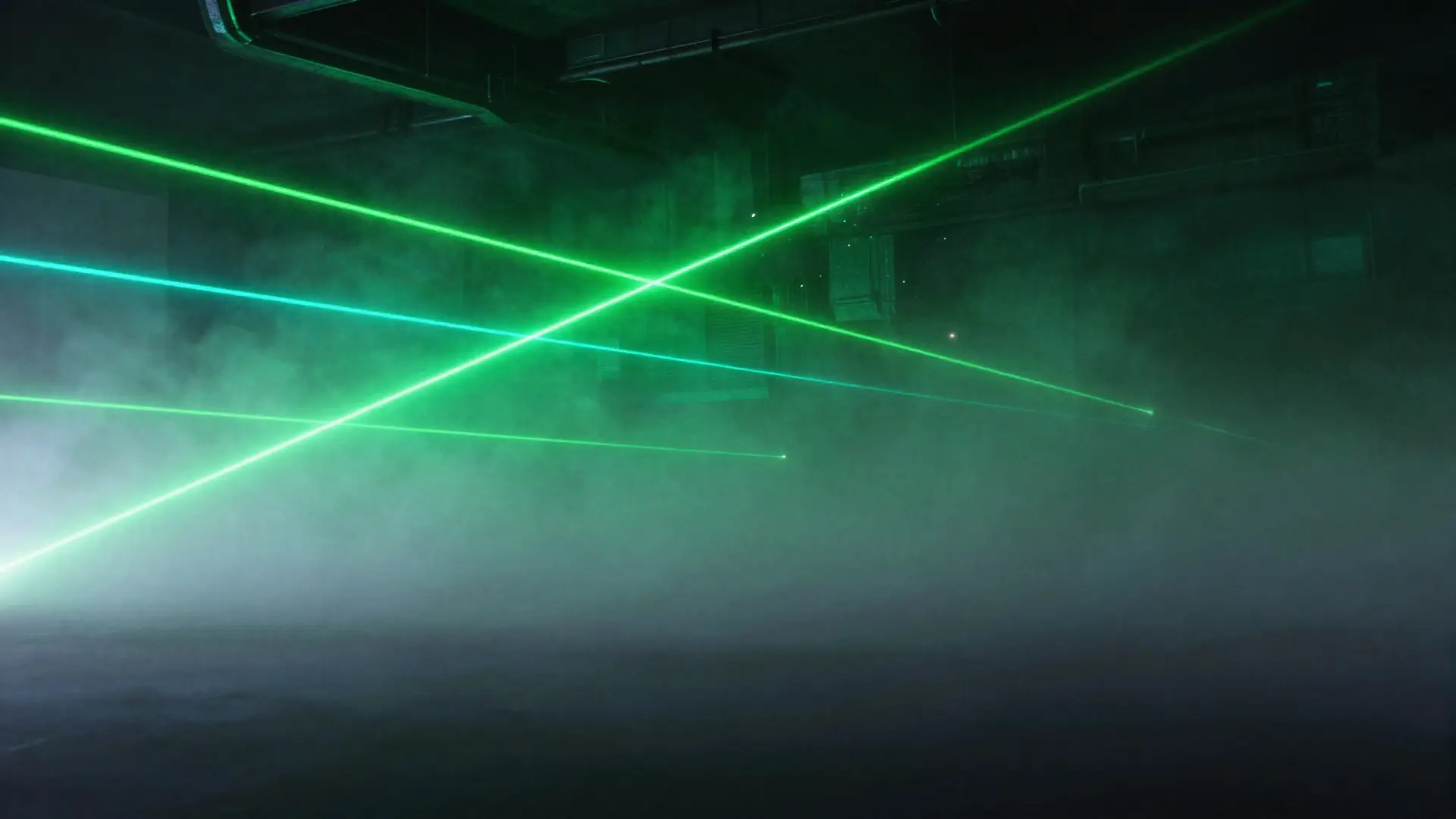 Green laser beams crossing through the haze of the empty arena